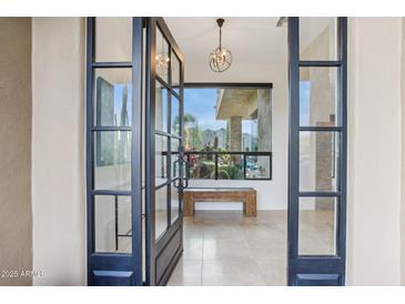Grand entryway with tile floors, modern light fixture and picturesque desert views at 38199 N Tranquil Way, Carefree, AZ 85377