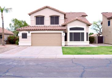 Charming two-story home featuring a tile roof, neutral stucco, and a well-manicured lawn at 488 W Harvard Ave, Gilbert, AZ 85233