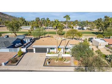 Beautiful single-story home featuring a well-manicured front yard and proximity to a lush green golf course at 544 W Thunderbird Rd, Phoenix, AZ 85023