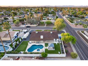 Stunning aerial view of the property featuring a pool, putting green, and outdoor gazebo, set against a backdrop of lush landscaping at 5975 E Larkspur Dr, Scottsdale, AZ 85254