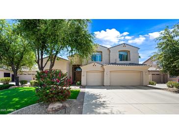 Charming two-story home with a well-manicured front yard, complemented by a beautiful flowering tree at 2069 S Sailors Ct, Gilbert, AZ 85295