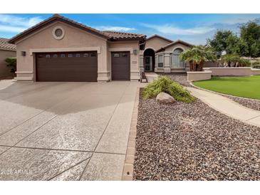 Charming single-story home with a well-manicured lawn, brown roof, and wide driveway at 2088 N 164Th Ave, Goodyear, AZ 85395