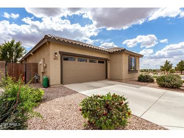 Charming single-story home with a well-manicured lawn and a spacious two-car garage at 20941 E Pecan Ln, Queen Creek, AZ 85142