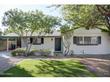 Charming home with well-maintained lawn, mature trees and white painted brick at 2533 E Flower St, Phoenix, AZ 85016