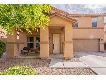 Inviting home featuring a charming front porch, two-car garage, and low maintenance desert landscaping at 2939 W Sunshine Butte Dr, San Tan Valley, AZ 85144