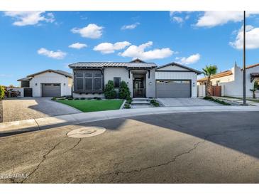 Charming single-story home featuring manicured landscaping, a metal roof, and a welcoming driveway at 3842 E Alameda Ln, Gilbert, AZ 85298