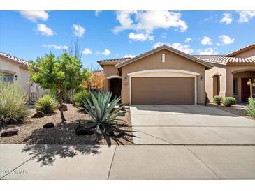 Charming single-story home with a well-manicured desert landscape and a two-car garage at 40055 N High Noon Way, Anthem, AZ 85086