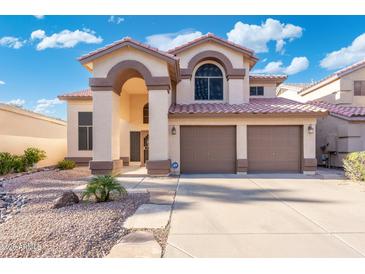 Inviting two-story home featuring a terracotta roof and a spacious two-car garage at 4446 E Woodridge Dr, Phoenix, AZ 85032
