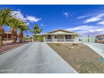 Charming single-story home featuring a front porch, covered parking, and desert landscaping at 67 S Amulet Ave, Mesa, AZ 85208