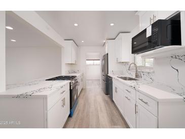 Bright kitchen featuring white cabinets, stainless steel appliances, and marble countertops at 7041 E Cypress St St, Scottsdale, AZ 85257