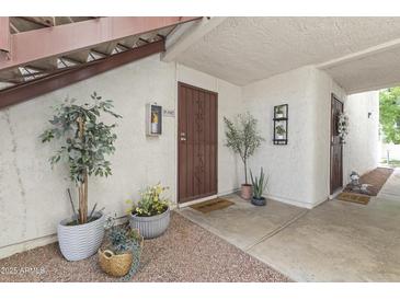 Inviting entrance with stylish potted plants, textured walls, and warm lighting that lead to a cozy home interior at 7350 N Via Paseo Del Sur -- # P107, Scottsdale, AZ 85258