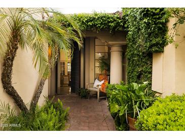 Inviting front entrance with brick pathway, lush greenery, and a charming bench at 7500 E Mccormick Pkwy # 73, Scottsdale, AZ 85258