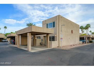 Beige two-story home with covered parking and a well-maintained landscape of rocks and trees at 7827 E Parkview Dr, Mesa, AZ 85208