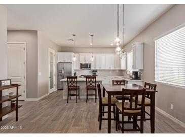 Spacious open-concept kitchen with white cabinets, stainless steel appliances, and an adjacent dining area at 8026 S 6Th Dr, Phoenix, AZ 85041