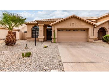Charming single-story home showcasing desert landscaping and a two-car garage at 11163 E Laurel Ln, Scottsdale, AZ 85259