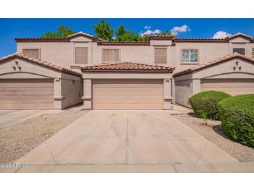 Inviting townhome featuring a private garage, neutral stucco, and a tile roof creating great curb appeal at 125 S 56Th St # 100, Mesa, AZ 85206