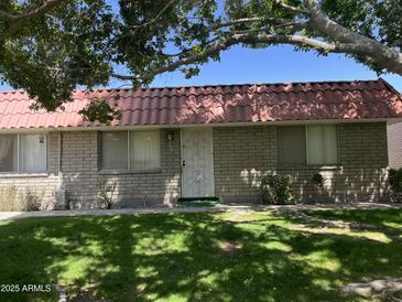 Charming single-story home with a red tile roof, well-maintained lawn, and mature shade trees in a desirable neighborhood at 141 N Date -- # 7, Mesa, AZ 85201