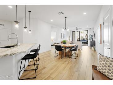 Bright living space features an open floor plan, modern lighting fixtures, and access to an outdoor patio area at 2511 W Queen Creek Rd # 165, Chandler, AZ 85248
