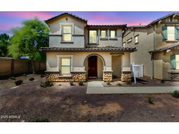 Charming two-story home with stone accents and arched entryway, perfect for a Gathering at 3841 E Jasper Dr, Gilbert, AZ 85296