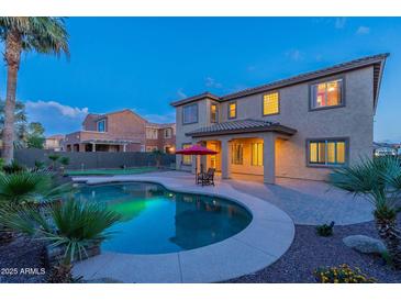 Backyard features a pool, patio and lush landscaping against the backdrop of the home's exterior at 4894 E Palm Beach Dr, Chandler, AZ 85249