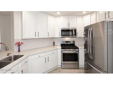Stylish kitchen features stainless steel appliances, white cabinetry, and light countertops at 5350 E Deer Valley Dr # 2435, Phoenix, AZ 85054