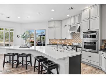 Spacious kitchen featuring a large island with seating and stainless steel appliances at 8235 E Sierra Pinta Dr, Scottsdale, AZ 85255