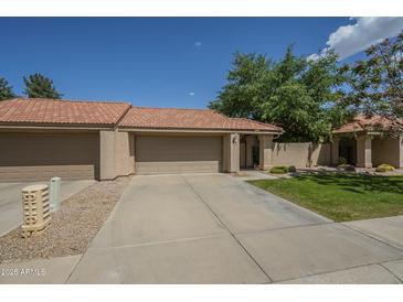 Charming home featuring a terra cotta roof, a two-car garage, and a well-maintained front lawn at 945 N Pasadena -- # 84, Mesa, AZ 85201