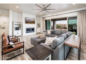 Spacious living room with a modern fireplace, comfortable seating, and view of the outside landscape at 15223 E Lone Mountain Rd, Scottsdale, AZ 85262