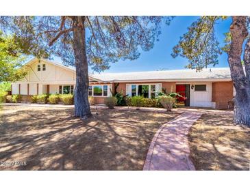 Charming single-story home with brick accents, surrounded by well-manicured landscaping and mature trees, creating a welcoming curb appeal at 4350 E Vermont Ave, Phoenix, AZ 85018