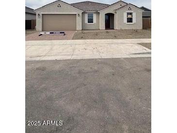 Charming single-story home with desert landscaping, a two-car garage, and a welcoming entrance at 14742 W Lariat Trl, Surprise, AZ 85387