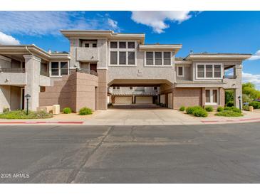 Inviting exterior of a multi-story townhome featuring stucco and a covered car port against a backdrop of blue sky and clouds at 15221 N Clubgate Dr # 2132, Scottsdale, AZ 85254