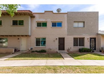 Charming townhome featuring a well-maintained lawn and a classic brick facade at 225 N Standage -- # 30, Mesa, AZ 85201