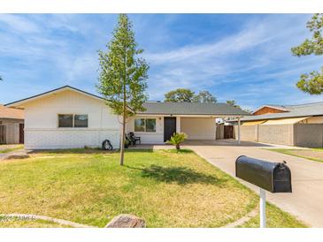 Charming single-story home with a well-maintained lawn, covered parking, and a welcoming front entrance at 234 S Neely St, Gilbert, AZ 85233