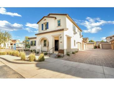 Beautiful two story home with stucco exterior, arched porch entry, manicured landscaping, and brick paved driveway at 2491 N 149Th Ln, Goodyear, AZ 85395
