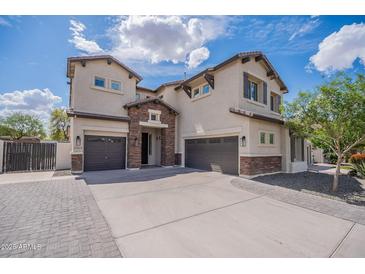 Stunning two-story home with three-car garage and stone accents on a sunny day at 2969 E Trigger Way, Gilbert, AZ 85297