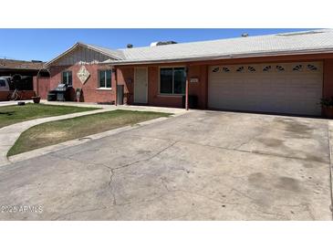 Charming single story home with a well manicured lawn, spacious driveway, and a one car garage at 3020 N 64Th Dr, Phoenix, AZ 85033