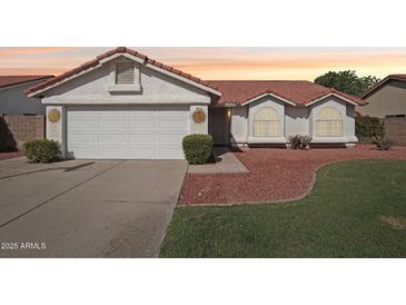 Charming single-story home with a well-maintained lawn and two-car garage at 3528 N Crystal Ln, Avondale, AZ 85392