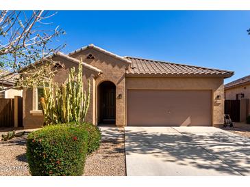 Charming single-story home with desert landscaping, tile roof, and a two-car garage, all under a clear blue sky at 37852 W Merced St, Maricopa, AZ 85138
