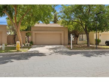 Charming single-story home with a two-car garage and a well-maintained front yard with mature trees and desert landscaping at 5 W Ranch Rd, Tempe, AZ 85284