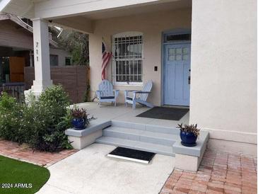 Charming front porch featuring two blue Adirondack chairs, perfect for relaxing outdoors at 711 E Mckinley St, Phoenix, AZ 85006