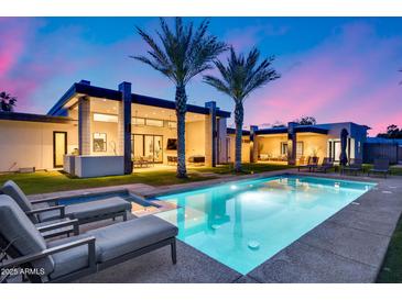 Relaxing backyard with a sparkling pool, lounge chairs, and palm trees, perfect for outdoor enjoyment at 12809 N 67Th St, Scottsdale, AZ 85254