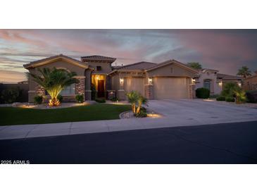 Charming single-story home with a three-car garage, well-manicured lawn, and stone accents at 15664 W Vernon Ave, Goodyear, AZ 85395