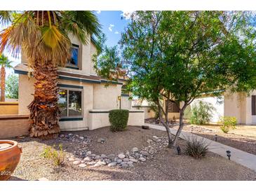 Charming home exterior featuring desert landscaping and a mature palm tree, enhancing curb appeal at 16496 N 68Th Ave, Peoria, AZ 85382