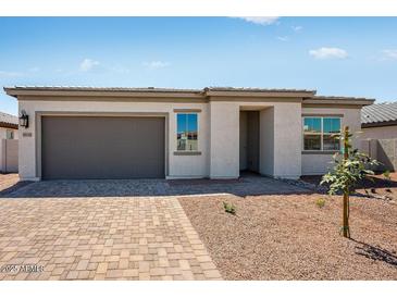 Charming single-story home featuring a gray garage door and desert landscaping at 18147 W Tanglewood Dr, Goodyear, AZ 85338