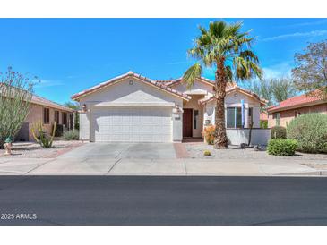 Charming single-story home featuring desert landscaping, a two-car garage, and a welcoming front entrance with mature landscaping at 2464 E Hancock Trl, Casa Grande, AZ 85194