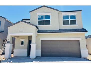 Two-story home featuring a two-car garage, covered porch, and a modern design with neutral stucco and tile roof at 5075 E Umber Rd, San Tan Valley, AZ 85143
