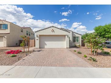 Charming single-story home with a brick driveway, a two-car garage, and desert landscaping at 5312 W Hardtack Trl, Laveen, AZ 85339