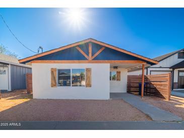 Charming home featuring a striking blue gable, wood accents, and a neatly landscaped front yard at 576 N Pasadena --, Mesa, AZ 85201