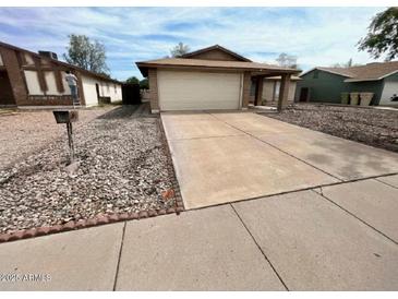 Charming single-story home with a large driveway and attached two-car garage at 6231 W Zoe Ella Way, Glendale, AZ 85306