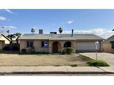 Modest one-story home with attached garage and minimal landscaping under a blue sky at 7961 W Campbell Ave, Phoenix, AZ 85033